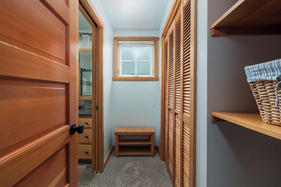 Your private hallway features warm wood accents and organized storage, creating a welcoming transition between your comfortable spaces.