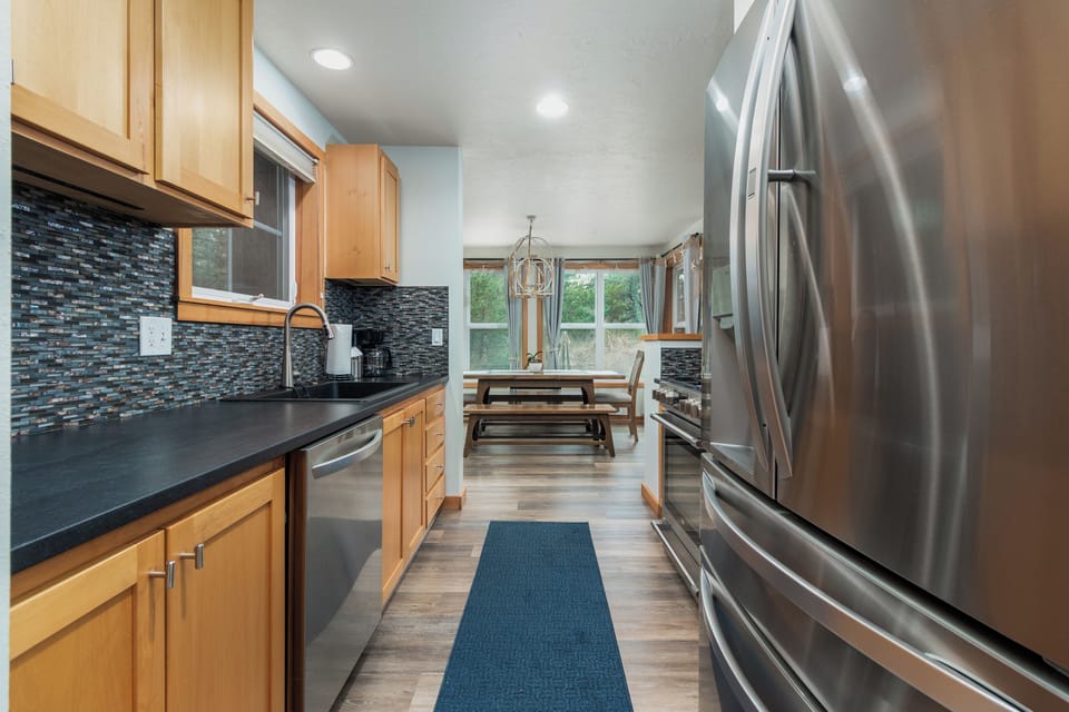 Your gourmet kitchen features stainless steel appliances and stunning blue tile backsplash, perfect for creating memorable meals during your stay.