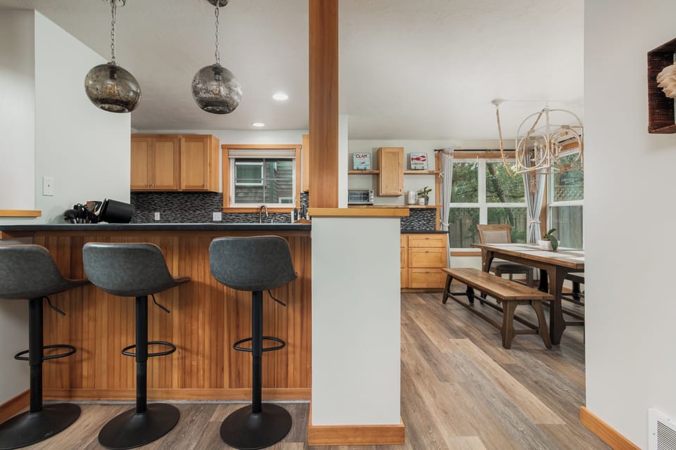 Your open-concept kitchen flows seamlessly into the dining area, where warm wood accents and stylish lighting create the perfect space for memorable meals.