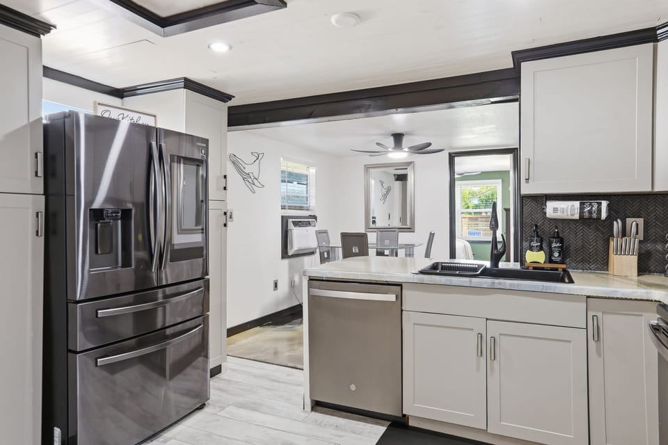 Bright modern kitchen with stainless appliances and open dining flow