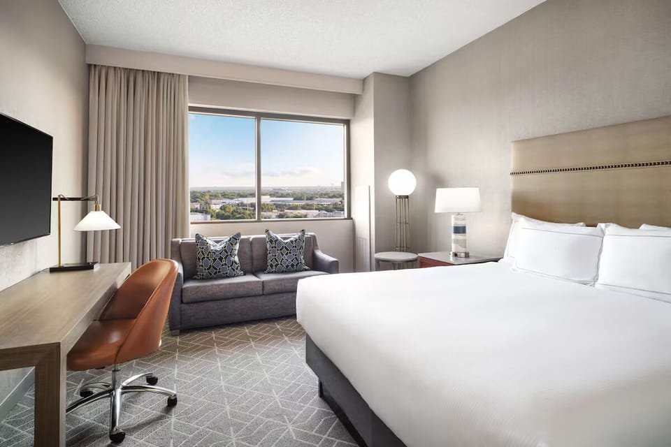 Wake up to bright skyline views from plush king bed