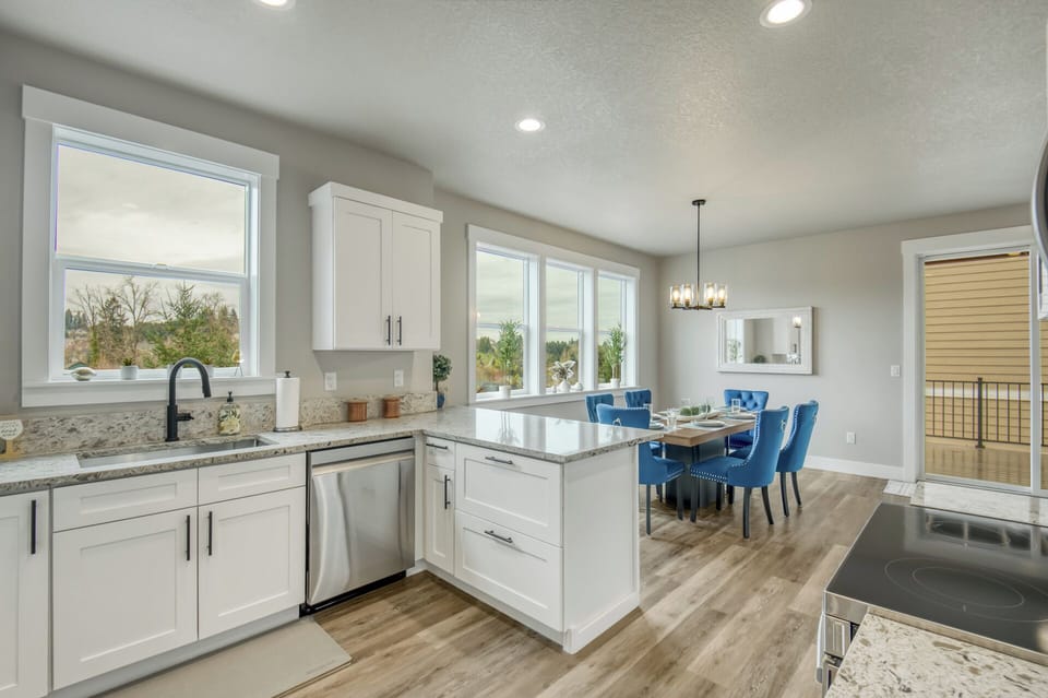 Modern kitchen flows seamlessly into the dining space, where quartz countertops and stainless steel appliances make cooking a joy.
