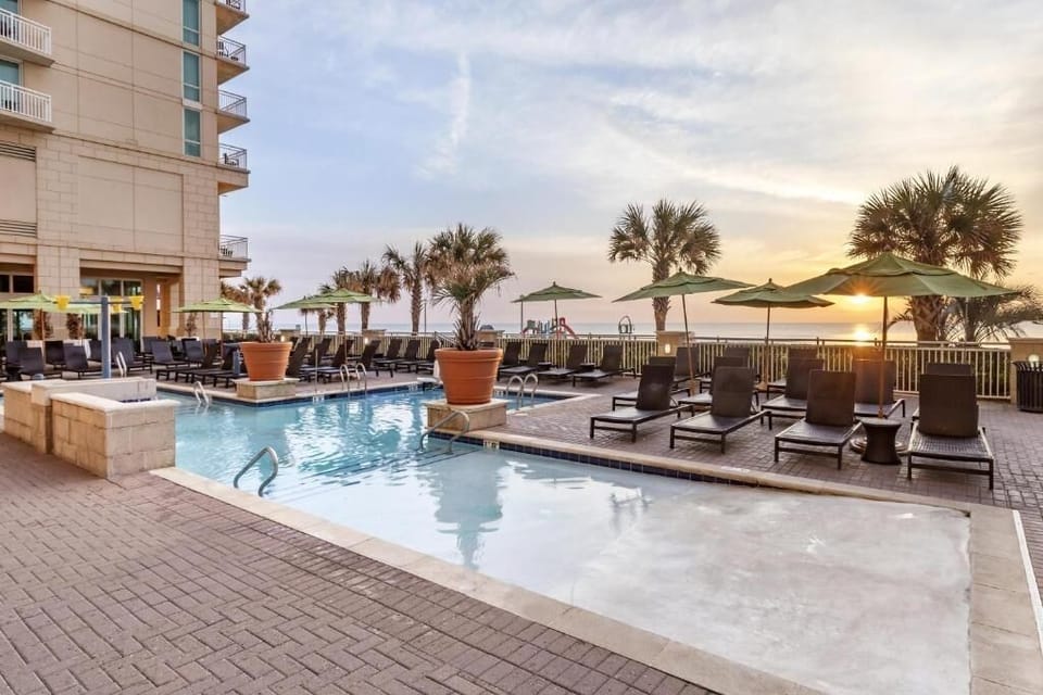Unwind at sunset beside the oceanfront pool and loungers.