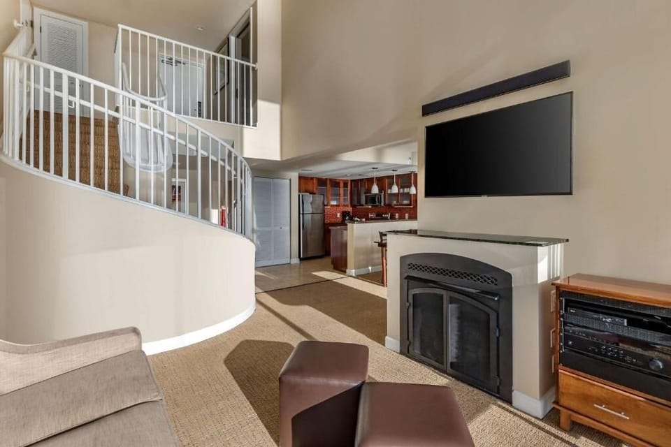 Gather by the fireplace in a lofty, sun-filled living room.
