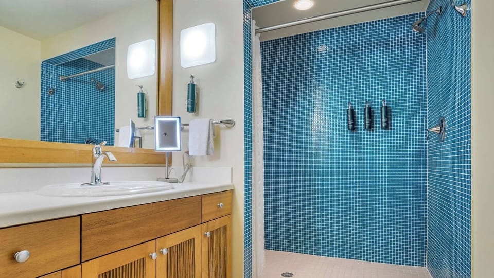 Refresh under a rainfall shower in sparkling blue tile.