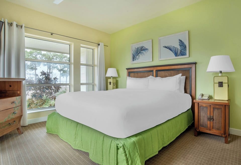 Unwind in a sunlit king bed with calming resort views.