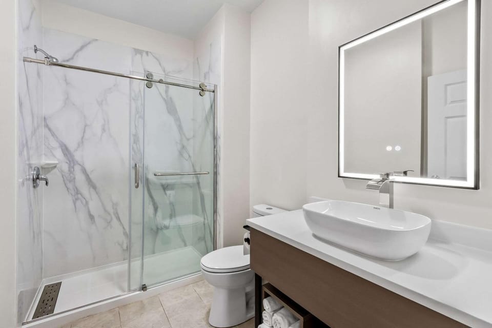 Refresh in a sleek bathroom with a glass walk-in shower.