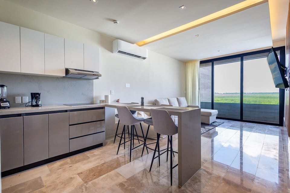 Modern kitchen and dining area with scenic balcony views of the mangrove