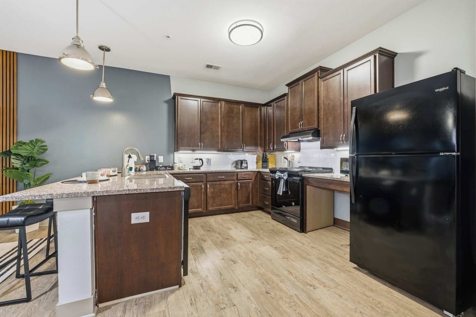 Modern kitchen with stainless steel appliances and breakfast bar.