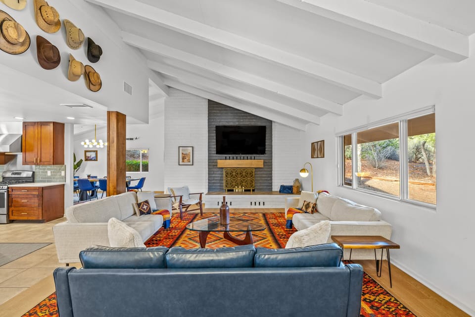 Comfortable living room with cozy seating, a fireplace, and large windows bringing in natural light.