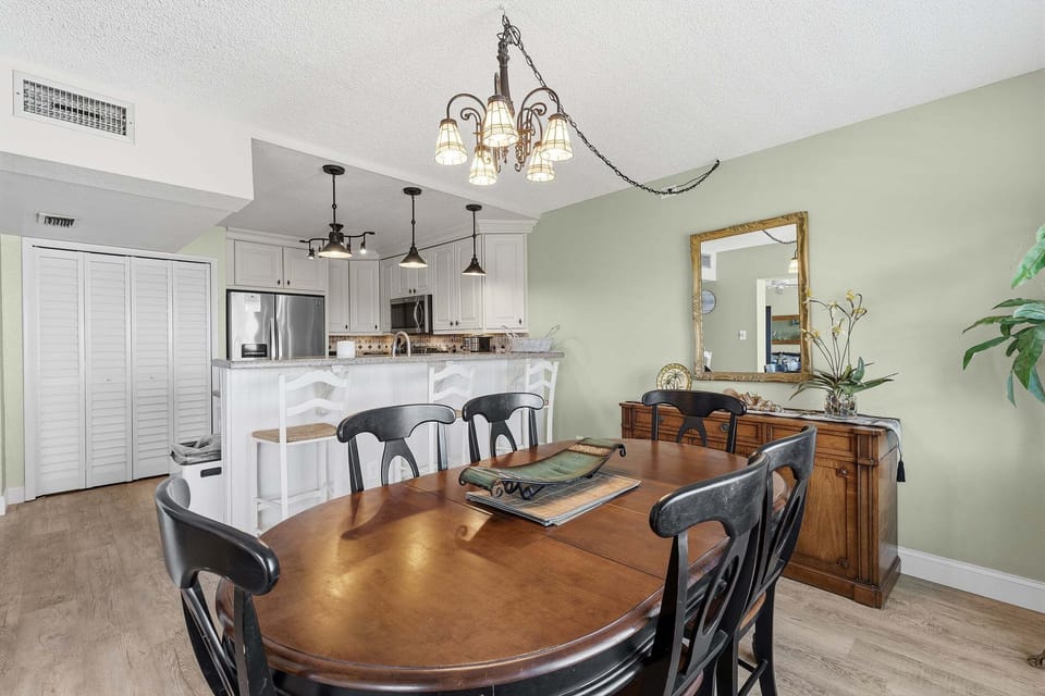 Gather for meals in this inviting coastal dining area featuring an open-concept kitchen and beach-inspired décor. Perfect for a relaxing beach stay with plenty of space to dine, unwind, and enjoy time together.