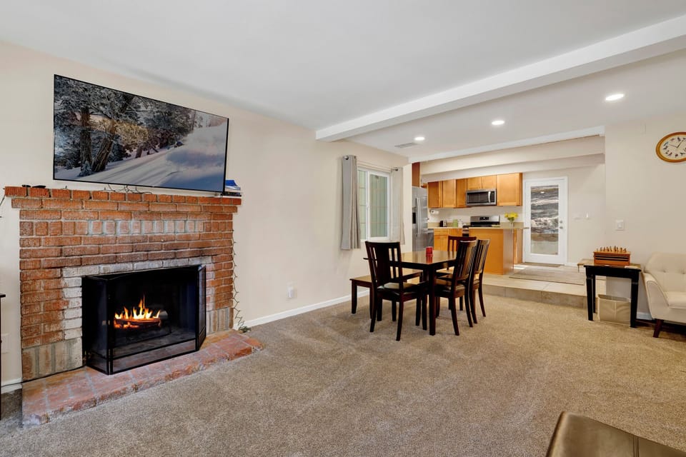 Cozy mountain living room with a stone fireplace, comfy seating, and smart TV—perfect for relaxing evenings, movie nights, and warm cabin vibes after outdoor adventures.