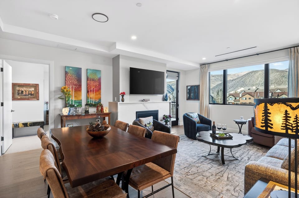 Open dining and living space with mountain views and a cozy fireplace.