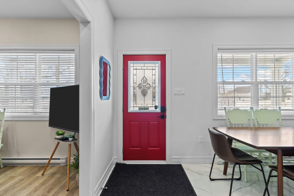 Welcoming entryway with bold red door and bright natural light