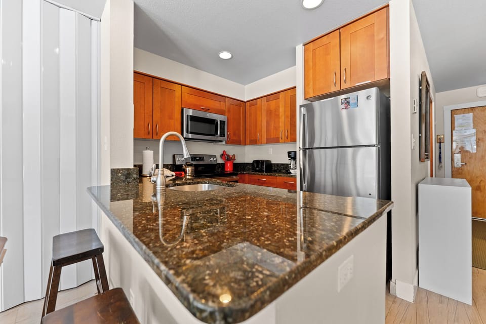 Your fully equipped kitchen features granite countertops, stainless steel appliances, and warm wood cabinets—perfect for preparing memorable meals.