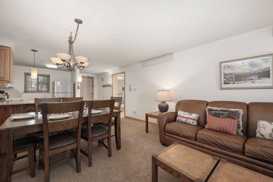 Relax in your cozy living space with comfortable leather seating and mountain artwork creating the perfect alpine retreat atmosphere.