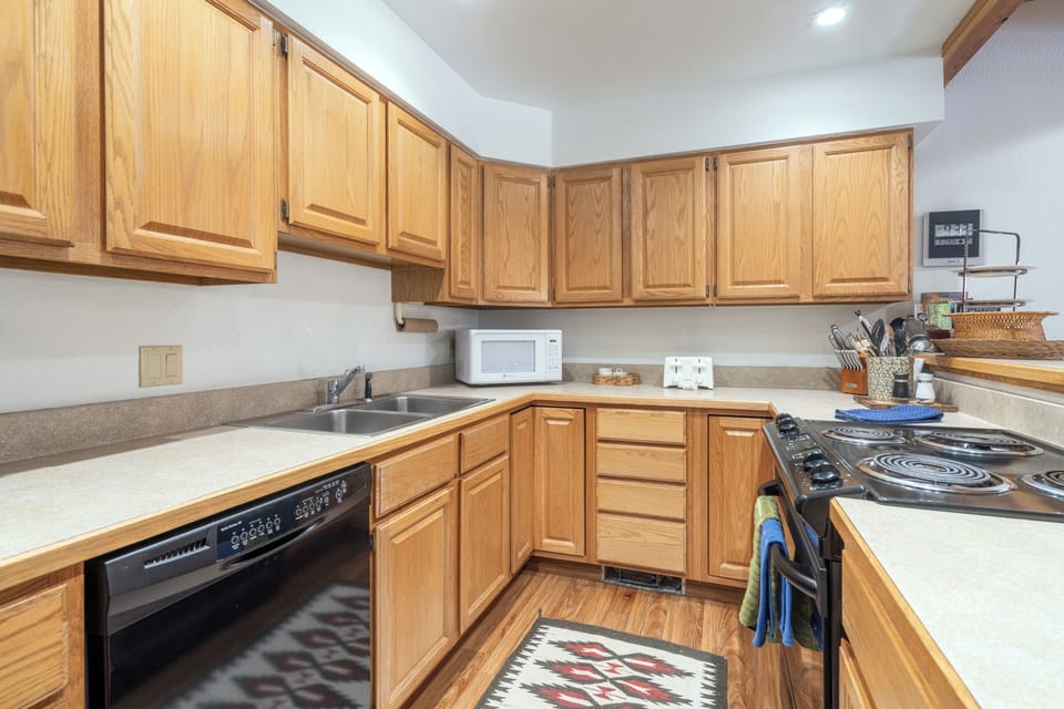 Your fully equipped kitchen features warm oak cabinetry, modern appliances, and ample counter space for preparing memorable meals during your stay.