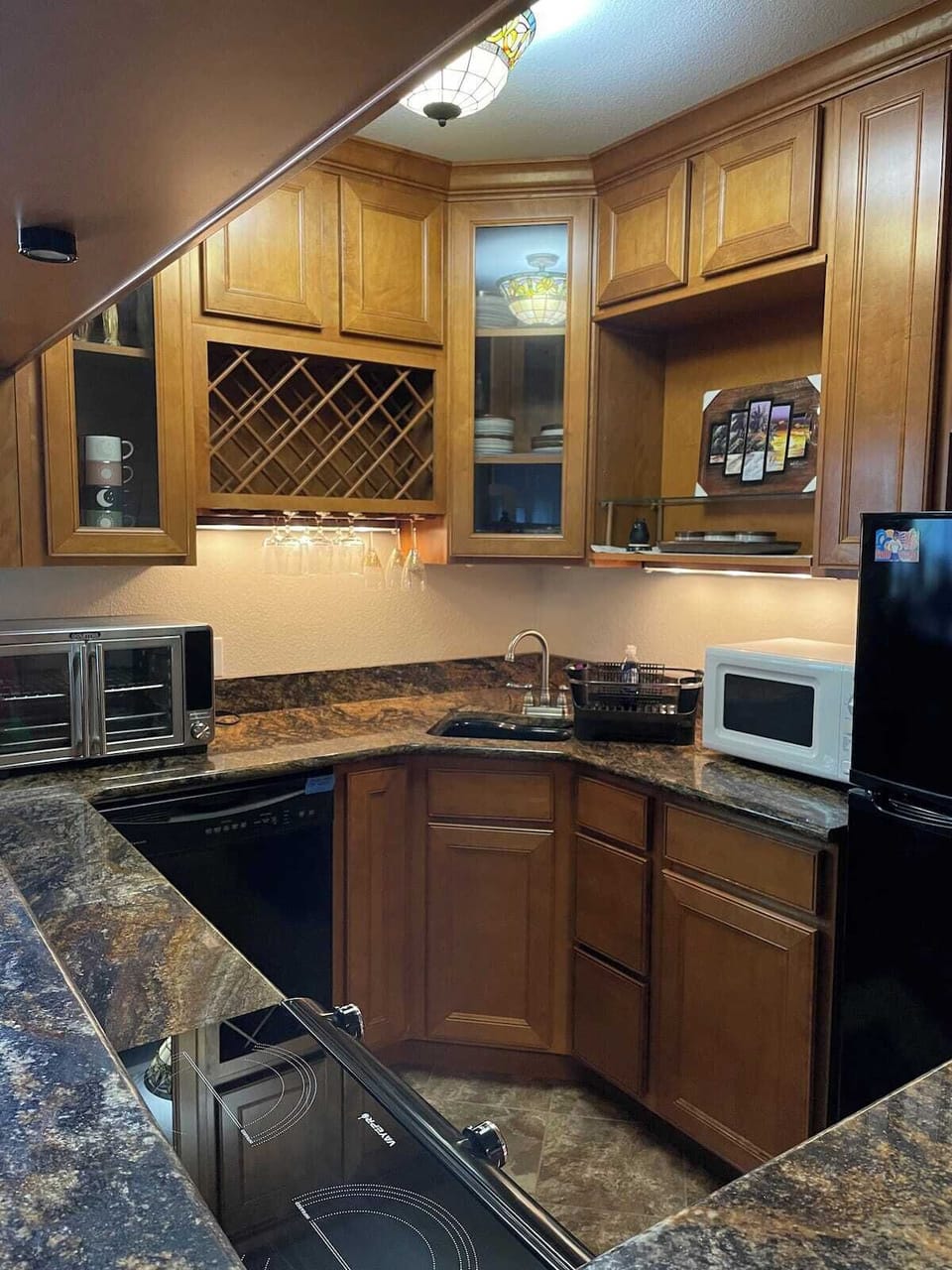 Kitchen with cooking utensils, counter top oven and two burner hot plate.