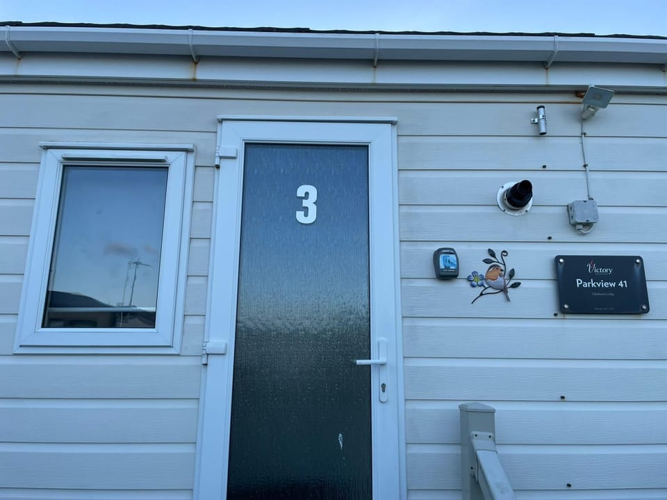 Modern 3 bedroom holiday lodge exterior at Victory Parkview 41, featuring grey cladding and a lovely entrance for self-catering accommodation.