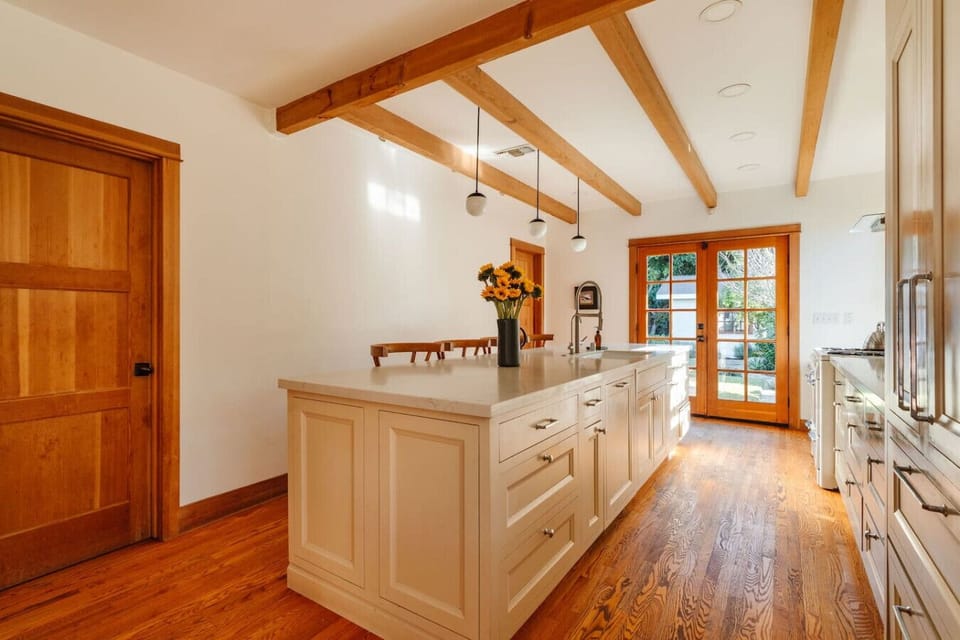 Well-appointed kitchen island with ample prep space, warm wood details, and natural light — ideal for cooking and gathering.