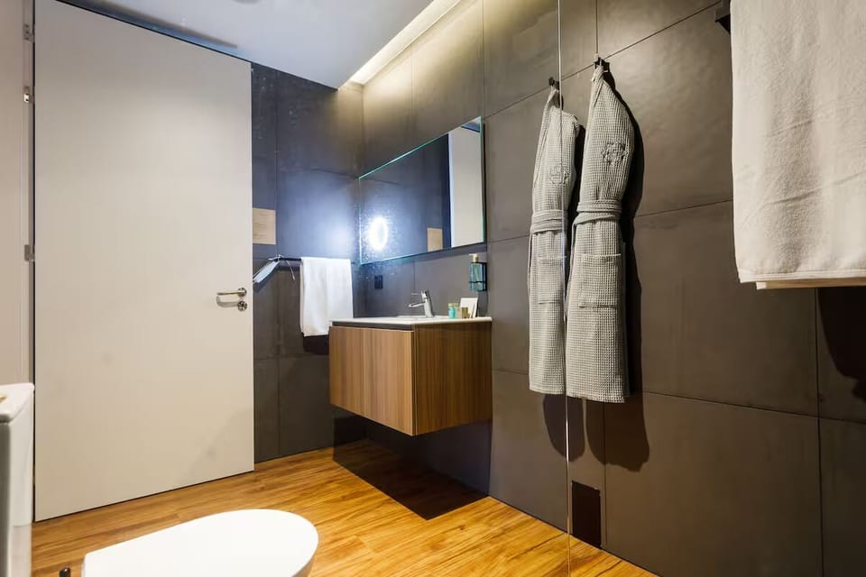 Refresh at the modern vanity with plush robes ready.