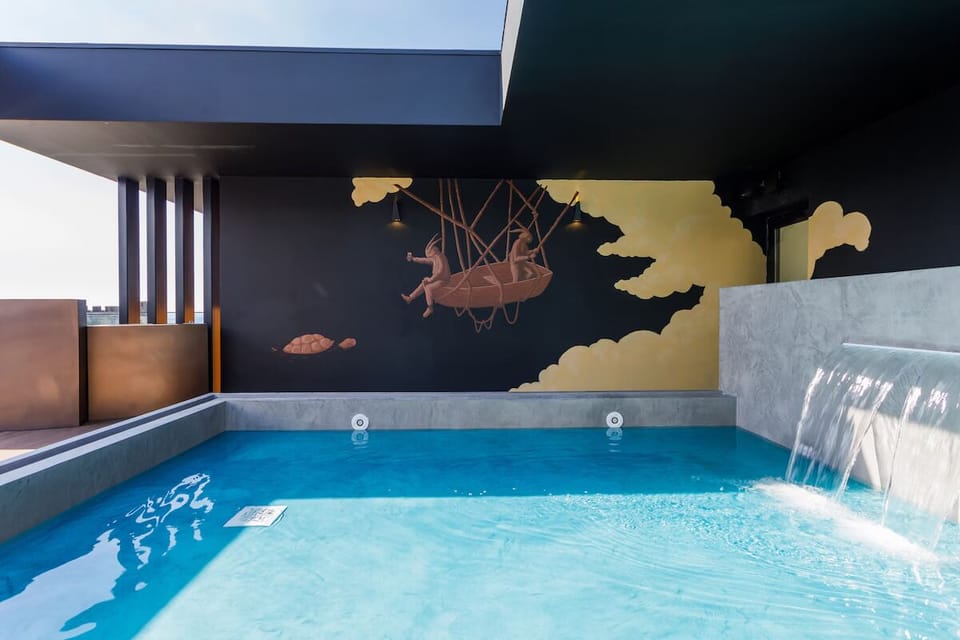 Cool off in the rooftop pool beneath open blue skies.