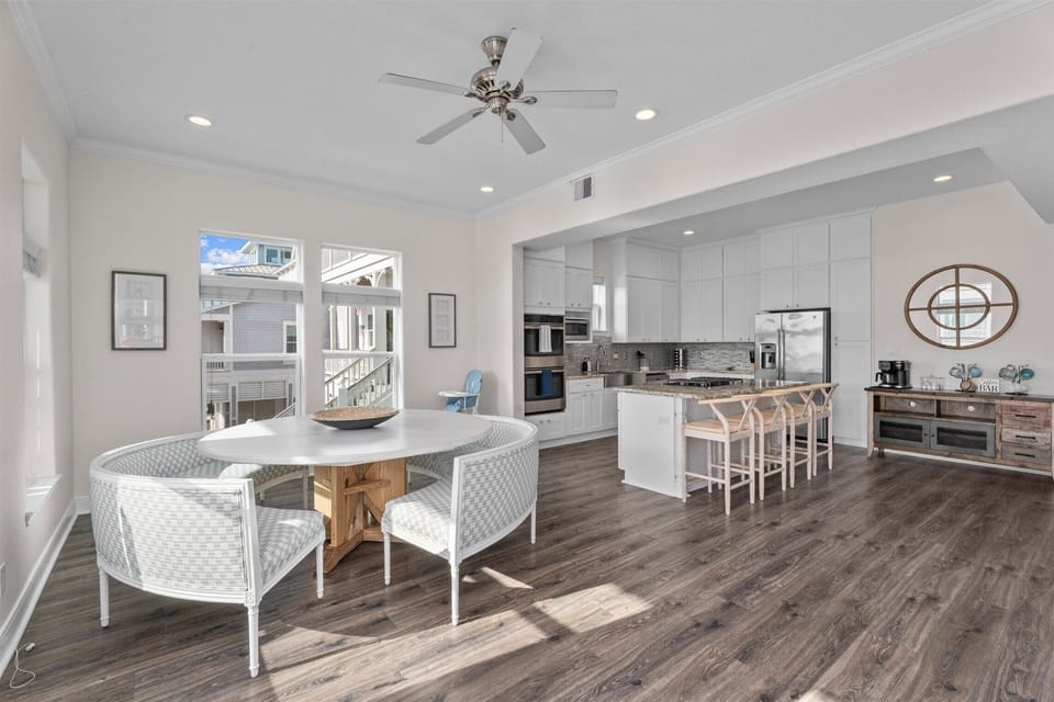 Large open living, dining, and kitchen layout with modern furnishings and plenty of natural light in this Galveston beach house.