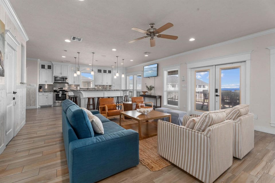 Wide living room layout with multiple seating areas and coastal-style furnishings