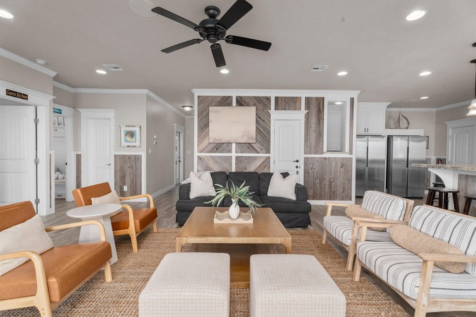 Bright living room with sectional seating, modern decor, and ceiling fan