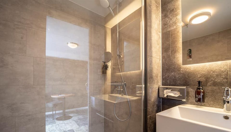 Unwind with warm lighting and a crisp, modern vanity.
