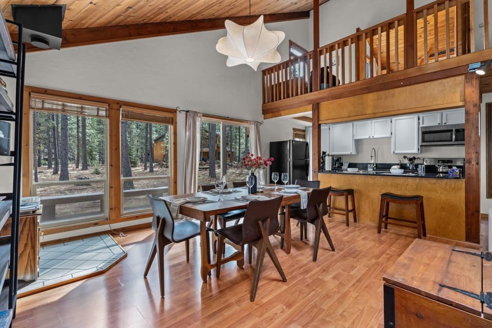 Gather around your dining table in this airy retreat, where warm wood tones and forest views create the perfect setting for shared meals.