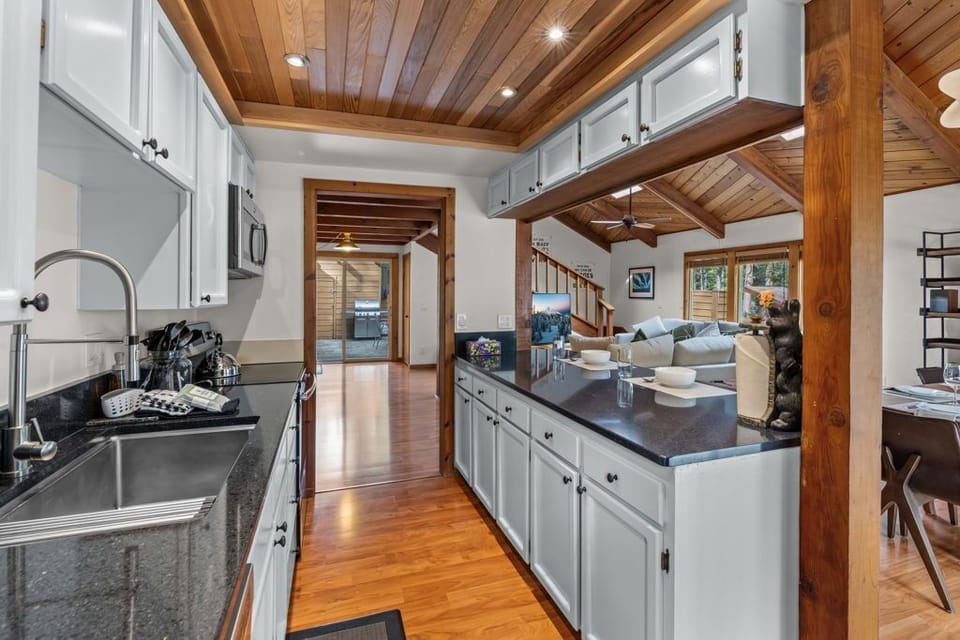 Your gourmet kitchen flows seamlessly into the warm living space, featuring exposed beams and everything you need for memorable meals.