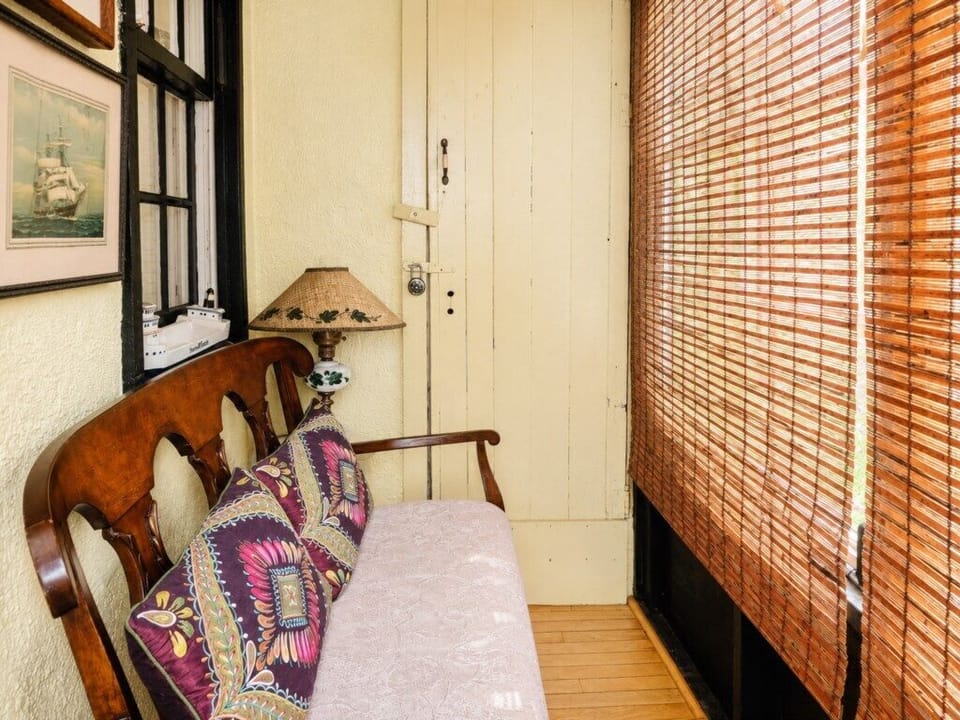 A cozy enclosed porch offers an extra little spot to sit and unwind.