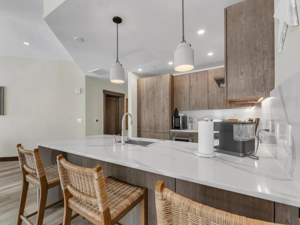 Modern kitchen with spacious island and woven bar stools