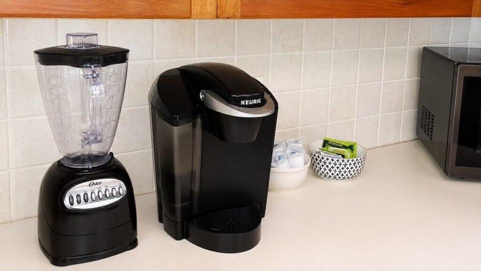 Coffee station with Keurig, blender and complimentary beverage supplies.