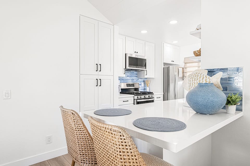 Galley kitchen with bar seating for two and modern stainless steel appliances
                