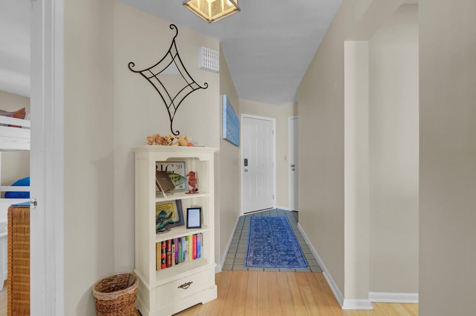 Hallway featuring a white bookshelf and a decorative wall piece.
