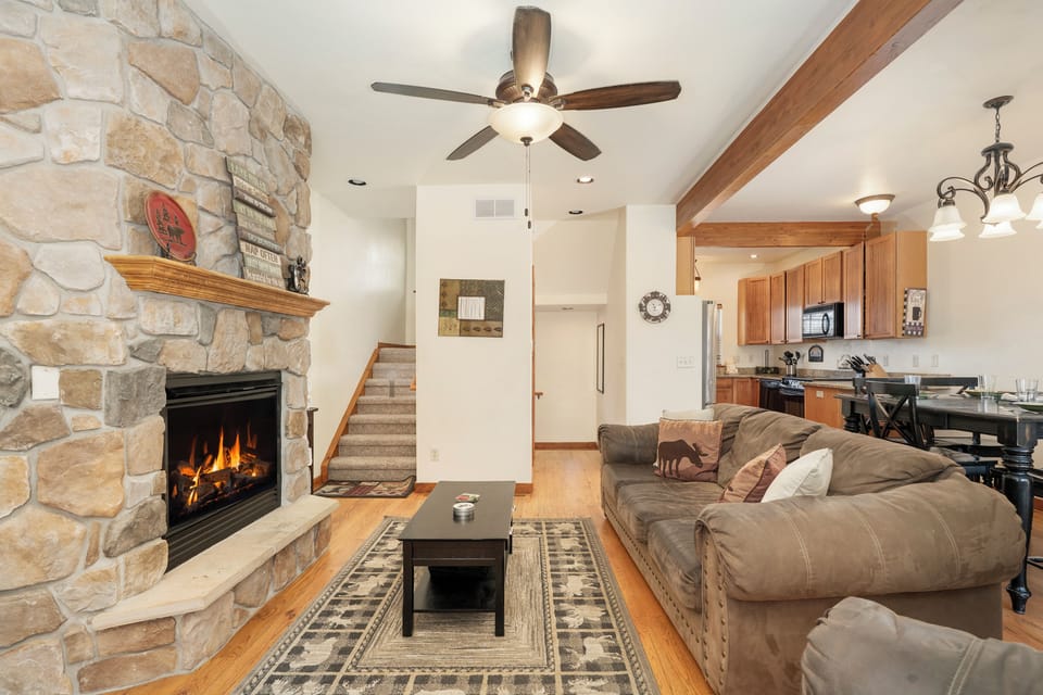 Cozy up by your crackling stone fireplace at Granby Lake Shore Estates Townhome 5 while planning meals in your fully-equipped kitchen—mountain comfort awaits.