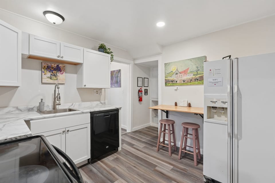 The kitchen includes a glass-top stove, dishwasher, folding wall table for two, and plenty of storage cabinets.