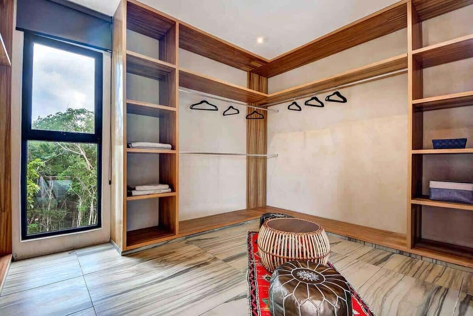 Spacious walk-in dressing area with ample storage and natural light.