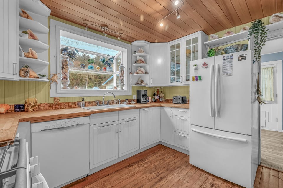 Your bright kitchen features wood countertops, white cabinets, and a cozy wood-beamed ceiling for memorable meal preparations.