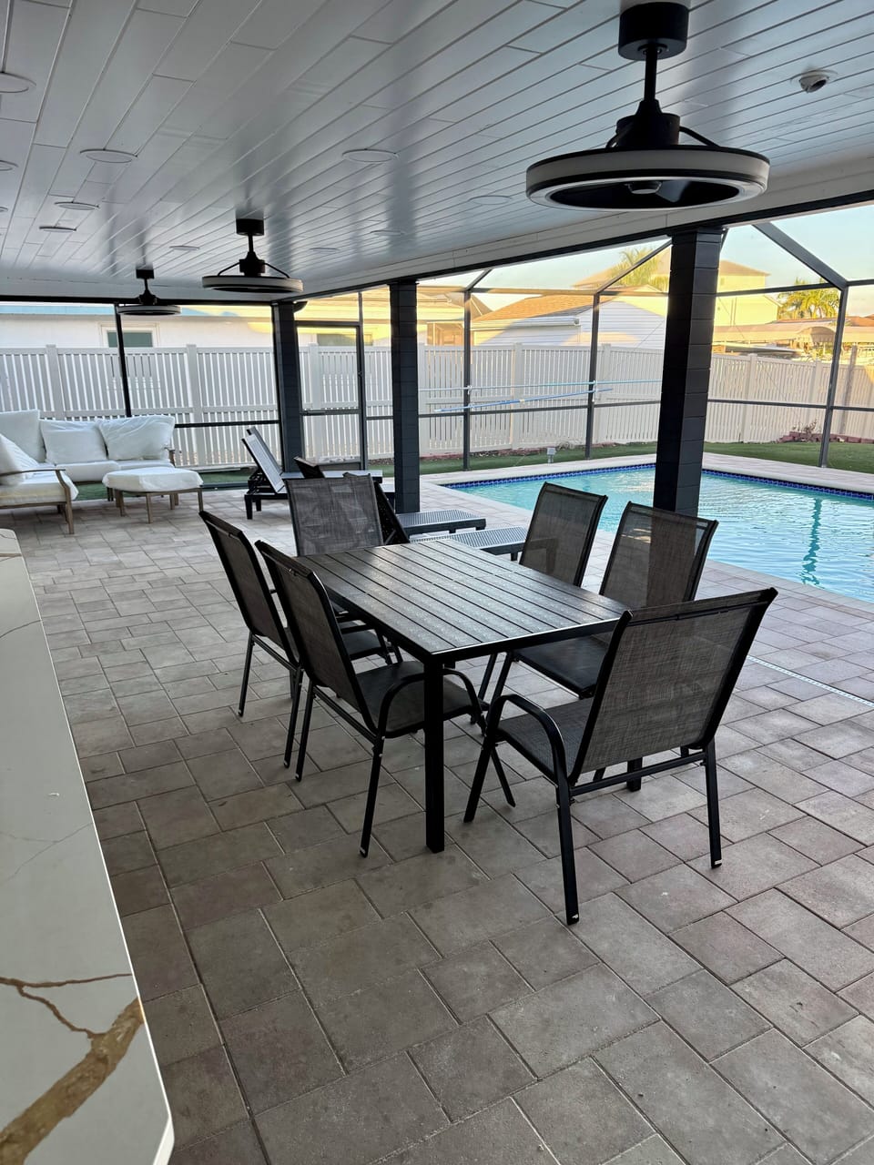 Relax at your covered outdoor dining table while watching the sparkling pool - perfect for morning coffee or evening meals.