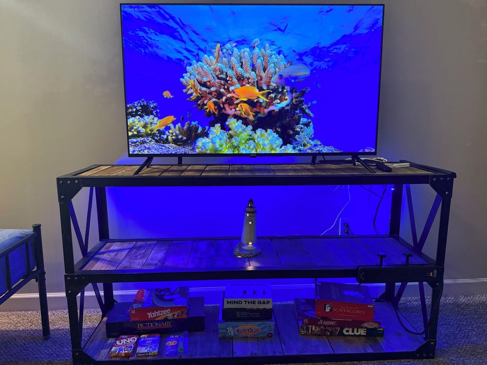 Entertainment setup with large TV, ambient lighting, and a collection of board games—perfect for movie nights or family fun after a day out.