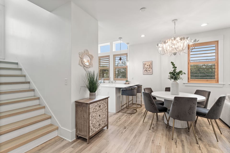 Enjoy elegant dining in your bright, modern space with stunning chandelier and natural light streaming through beautiful windows.
