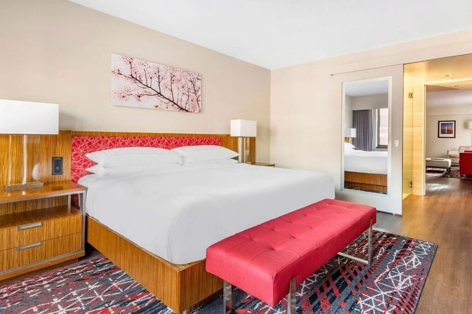 Unwind in a serene king bed with stylish red accents.