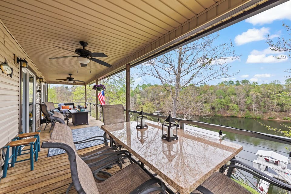 Covered porch dining area with large table overlooking the water.