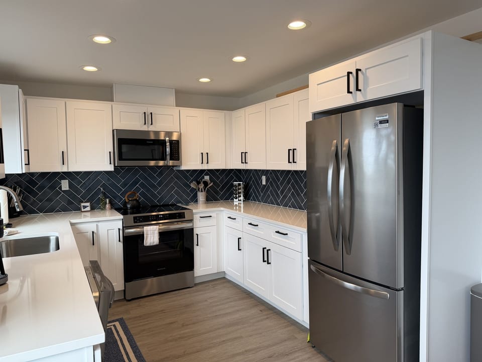 Modern Kitchen Paradise: Sleek appliances and stylish herringbone backsplash inspire culinary creativity!