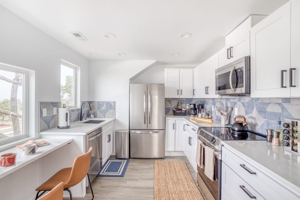 Charming Kitchen: Sleek appliances, stylish tile, and ocean views make cooking a delight!