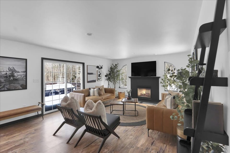 Bright great room made for gathering—fireplace glow, big-screen TV, and plenty of comfy seating for the whole crew.