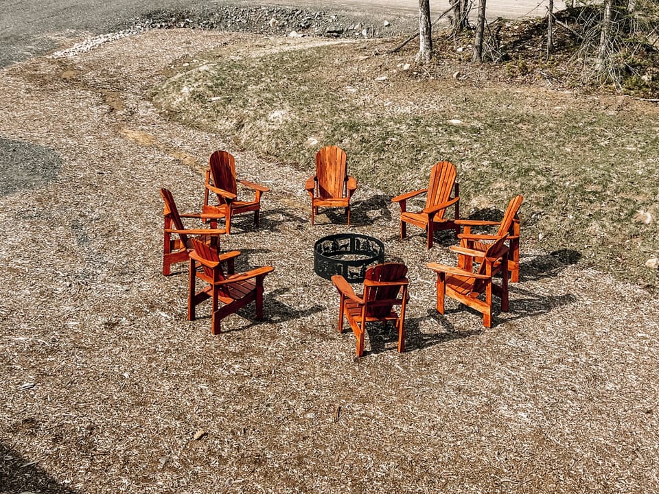 Fire pit with 8 wooden Adirondack chairs perfect for gathering at night